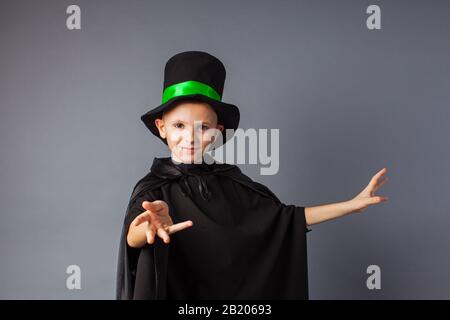 Piccolo mago fa trucchi. Il ragazzino indossa un mago e un cappello magico. Foto Stock