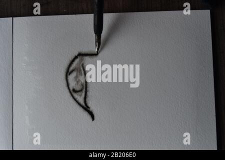 Sequenza di disegni, immergere la penna con inchiostro india su carta acquerello umida di un occhio Foto Stock