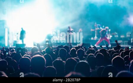 Gli appassionati di musica registrano video al telefono in folla durante il festival dei concerti. Foto Stock