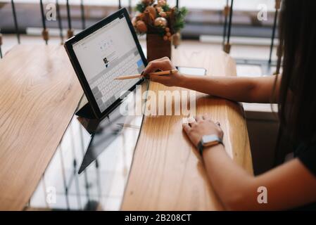 Primo piano delle mani di una ragazza irriconoscibile che scrive su un tablet digitale. Foto Stock