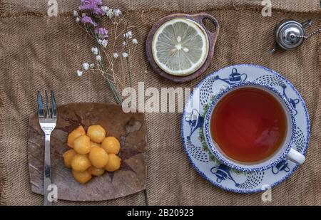 Pranzo - tè e limone Serviti con Thongyod (Dessert Thai) su un panno. Vista dall'alto, fuoco selettivo. Foto Stock