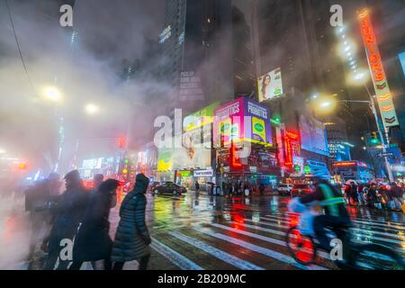 Il vapore che deriva circonda la gente, il traffico e gli edifici Di Times Square nella notte innevata al centro di Manhattan New York City NY USA il Gennaio 2020. Foto Stock