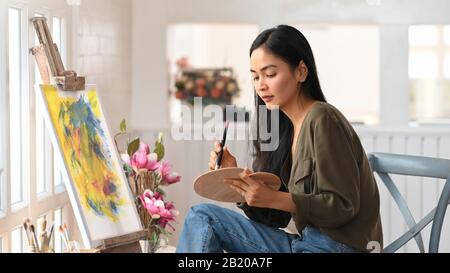 Donna artista opere su Abstract pittura acrilica in studio d'arte. Foto Stock