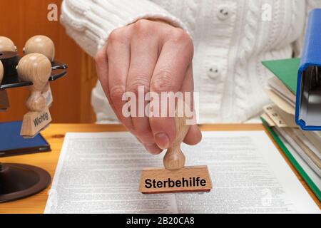 Un francobollo con l'iscrizione Sterbehilfe (suicidio Medicalmente assistito) è tenuto a mano Foto Stock