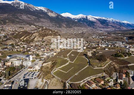 Veduta aerea della città di Sierre nel Canton Vallese con vigneti, e un castello e torre medievale che domina la valle del Rodano in Svizzera al sole Foto Stock