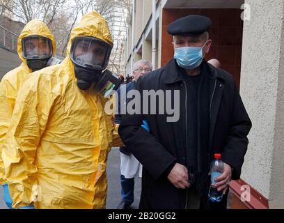 Gli operatori medici in indumenti protettivi accompagnano un uomo che agisce per avere il virus corona, durante l'esercizio di formazione sulla risposta del virus corona COVID-19, presso l'ospedale clinico Oleksandrivska.Nessun caso COVID-19 è stato segnalato in Ucraina, secondo il Ministero della Sanità dell'Ucraina. Foto Stock