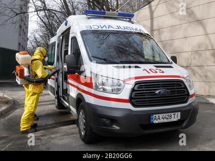 Un lavoratore medico in indumenti protettivi disinfetta un'automobile dell'ambulanza durante l'esercitazione di addestramento di risposta di coronavirus di COVID-19, all'ospedale clinico di Oleksandrivska a Kiev, Ucraina. A partire dal 28 febbraio 2020, in Ucraina non sono stati segnalati casi confermati dal COVID-19, secondo il Ministero della Sanità dell'Ucraina. Secondo il Ministero della Sanità dell'Ucraina, non sono stati segnalati casi di COVID-19. Foto Stock