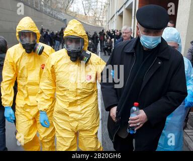 Gli operatori medici in indumenti protettivi accompagnano un uomo che agisce per avere il virus corona, durante l'esercizio di formazione sulla risposta del virus corona COVID-19, presso l'ospedale clinico Oleksandrivska.Nessun caso COVID-19 è stato segnalato in Ucraina, secondo il Ministero della Sanità dell'Ucraina. Foto Stock