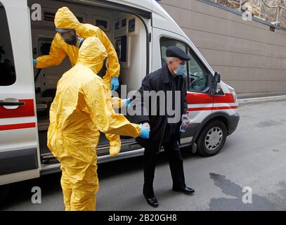 Gli operatori medici in indumenti protettivi accompagnano un uomo che agisce per avere il virus corona, durante l'esercizio di formazione sulla risposta del virus corona COVID-19, presso l'ospedale clinico Oleksandrivska.Nessun caso COVID-19 è stato segnalato in Ucraina, secondo il Ministero della Sanità dell'Ucraina. Foto Stock