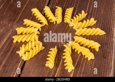 Lotto di pasta gialla intera fusilli cerchio su legno marrone Foto Stock