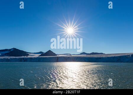 Sole di mezzanotte su Sefströmbreen, ghiacciaio in James i Land debouching in Ekmanfjorden, Svalbard / Spitsbergen, Norvegia Foto Stock