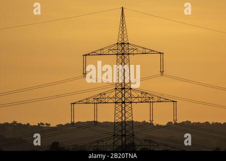 Strommast im Sonnenuntergang bei Gießen, Hessen, Deutschland Foto Stock