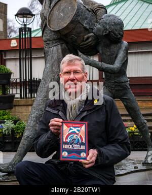 Tranent, East Lothian, Scozia, Regno Unito, 28th Febbraio 2020. Kenny MacAskill, recentemente eletto membro del Parlamento SNP per East Lothian, pubblica un nuovo libro il 27th febbraio 2020 (Biteback Publishing) chiamato 'Radical Scotland'. Un capitolo descrive il massacro di Tranent nel 1797 in cui Jackie Crookston, comparso nella scultura di David Annand dietro di lui, è stato ucciso Foto Stock