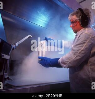 Austin Texas USA, 1994: High TECH Clean Room: Impiegato in 'Bunny Suit' mira a spruzzare CO2 cristalli pressurizzati sui componenti del computer all'interno di High-tec Foto Stock