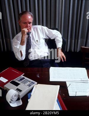 L'uomo d'affari nel suo ufficio prende una pausa dal lavoro sulla contabilità della sua azienda. ©Bob Daemmrich Foto Stock