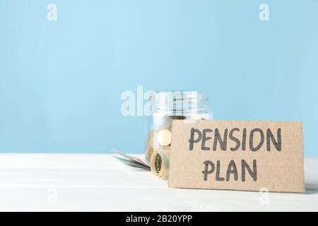 Iscrizione piano pensione e vaso con denaro su sfondo blu, spazio per il testo Foto Stock
