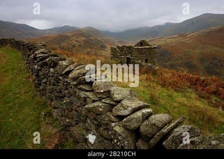 Un muro di pietra a secco e una capanna di pastore che si affaccia sul Passo di Kirkstone nel Distretto dei Laghi in Cumbria Foto Stock