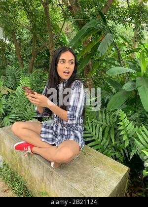 Giovane ragazza latina con smartphone, Panama City, Panama, America centrale Foto Stock
