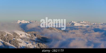 Vista dall'Hohe Salve, Kitzbuehler Horn a destra, Lofer Steinberge a sinistra, panorama di montagna in inverno, cime di montagna che torreggiano sopra la copertura nube Foto Stock