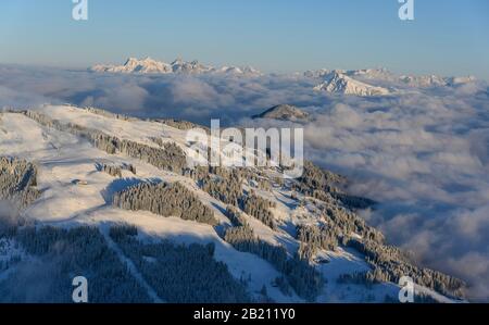 Vista dall'Hohe Salve, Kitzbuehler Horn e Lofer Steinberge, panorama di montagna in inverno, cime di montagna che torreggiano sopra la copertura nube, SkiWelt Foto Stock