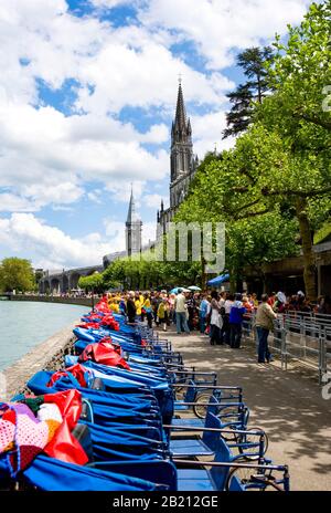 Pellegrini e sedie a rotelle di fronte alle terme, Basilica del Rosario e Basilica dell'Immacolata Concezione, Lourdes, Hautes Pyrenees, Francia Foto Stock