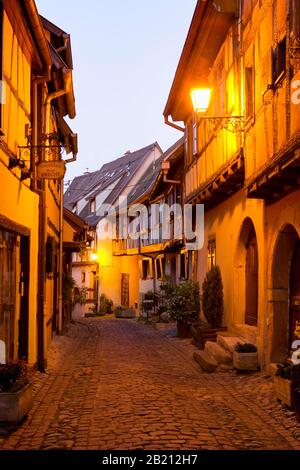 Vicolo della città vecchia alla luce della sera, Eguisheim, Alsazia, Francia Foto Stock