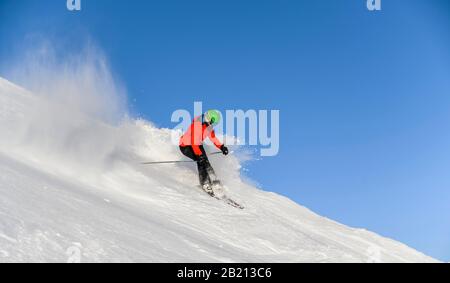 Sciatore discesa ripida pendenza, pista nera, cielo blu, SkiWelt Wilder Kaiser, Bressanone im Thale, Tirolo, Austria Foto Stock