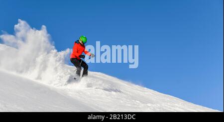 Sciatore discesa ripida pendenza, pista nera, cielo blu, SkiWelt Wilder Kaiser, Bressanone im Thale, Tirolo, Austria Foto Stock