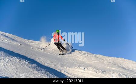 Sciatore discesa ripida pendenza, pista nera, cielo blu, SkiWelt Wilder Kaiser, Bressanone im Thale, Tirolo, Austria Foto Stock