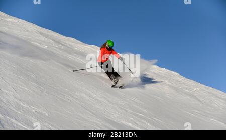 Sciatore discesa ripida pendenza, pista nera, cielo blu, SkiWelt Wilder Kaiser, Bressanone im Thale, Tirolo, Austria Foto Stock