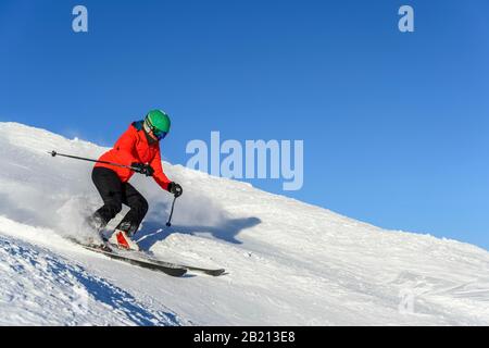 Sciatore discesa ripida pendenza, pista nera, cielo blu, SkiWelt Wilder Kaiser, Bressanone im Thale, Tirolo, Austria Foto Stock