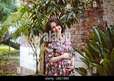 Ritratto di bella donna incinta in giardino Foto Stock