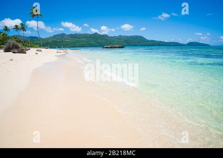 Una vista di spiaggia esotica con mare, sabbia e cielo blu, durante il giorno su una spiaggia pubblica a Rincon Beach, penisola di Samana, Repubblica Dominicana Foto Stock