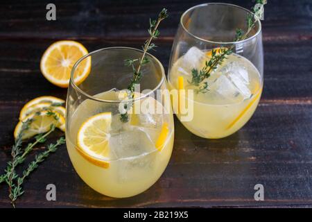 Meyer Lemon e Thyme Bees Ginocchia: Una versione aggiornata di un classico cocktail gin fatto con miele, Meyer limoni, e timo fresco Foto Stock