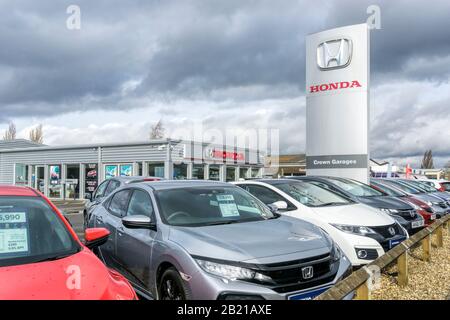 Vetture in vendita al di fuori di una concessionaria Honda con grande logo Honda sulla segnaletica. Foto Stock