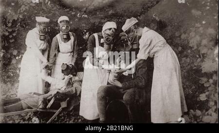 Gli infermieri di maschere a gas assistono le truppe nelle trincee durante la prima guerra mondiale. Foto Stock