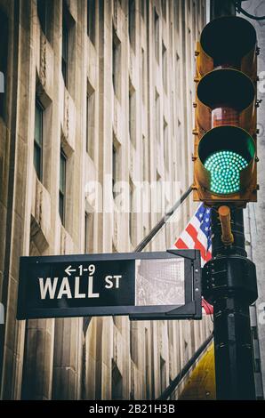 Wall Street segno primo con il semaforo verde vintage a Manhattan, New York City NYC e bandiera americana in background Foto Stock