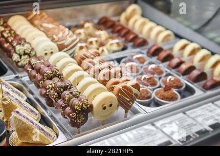 File di dolci al cioccolato e dessert nella finestra di una pasticceria. Presentate i dessert in una caffetteria o in una trattoria italiana. Foto Stock