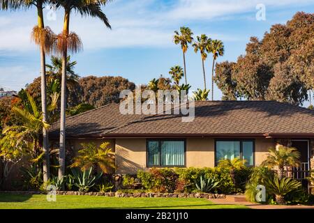 Bella casa California esterno con un giardino personalizzato e giardino con una varietà di piantare. Tratto da uno spazio pubblico nel febbraio 2020. Foto Stock