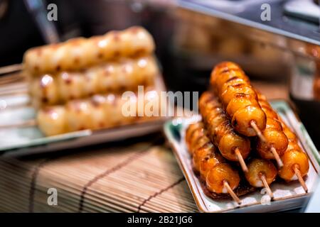 Esposizione di hot mochi dango snack con torta di riso e sciroppo di salsa di soia miso su bambù tradizionale Street food giapponese nel mercato Nishiki Foto Stock