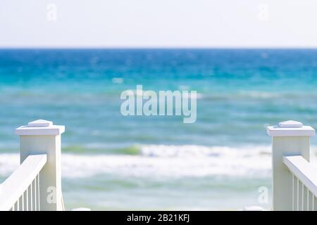 Lungomare, Florida bianca ringhiera scalinata in legno passerella giù vista dell'architettura sulla spiaggia oceano vista sfondo durante la giornata di sole e orizzonte Foto Stock
