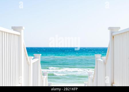 Lungomare, Florida ringhiera passerella in legno scala giù vista dell'architettura sulla spiaggia oceano vista sfondo durante la giornata di sole e orizzonte Foto Stock