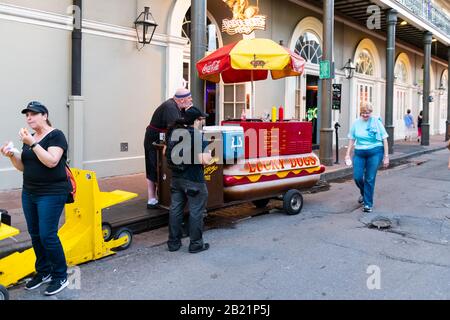 New Orleans, Stati Uniti - 22 aprile 2018: Lo stallo del cane caldo dei Lucky Dogs si trova su Bourbon Street con persone e venditori in serata Foto Stock