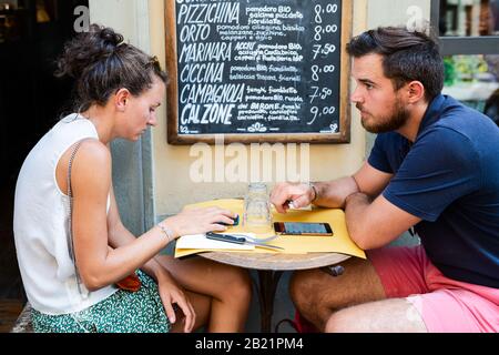 Firenze, Italia - 30 agosto 2018: Firenze vicino al mercato centrale caffetteria ristorante con coppie romantiche seduti su sedie da tavolo ordinando i menu pi Foto Stock