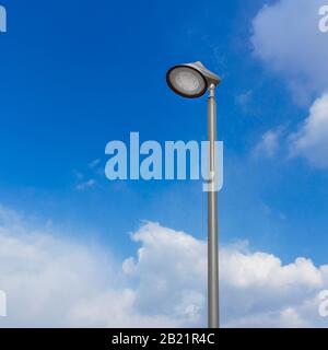 Lampione contro il cielo. Lampada a LED per strada con cielo blu e sfondo nube. Foto Stock