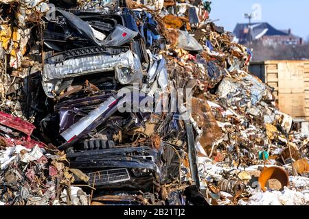 Un mucchio grande di metallo di scarto ad un deposito di riciclaggio. Auto, mesh e altri metalli assortiti non identificabili, tutti visibili. Profondità di campo bassa. Foto Stock