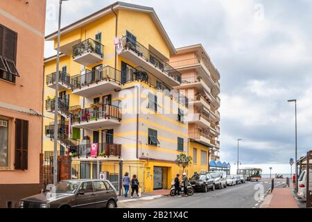 Una tipica e colorata strada suburbana lungo il lungomare della città di Ventimiglia, Italia, sul Mediterraneo italiano in una giornata torbida. Foto Stock