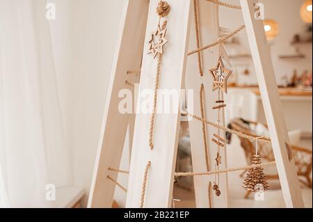 albero straordinario non-standard fatto di assi e corda di legno, con giocattoli di legno, decorazioni e una garland Foto Stock