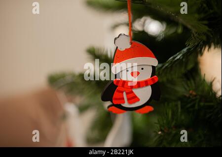 Giocattolo ecologico in legno per l'albero di Natale in forma di pinguino in un cappello rosso da vicino Foto Stock