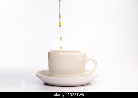 Caffè versato in una tazza bianca e piattino Foto Stock